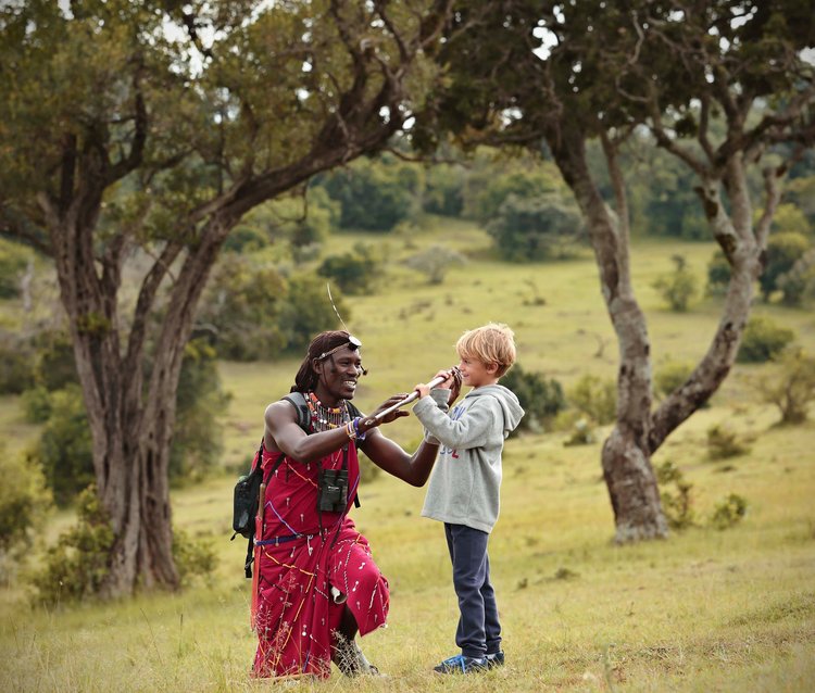 Kids on a walking safari with a maasai warrior in Kenya